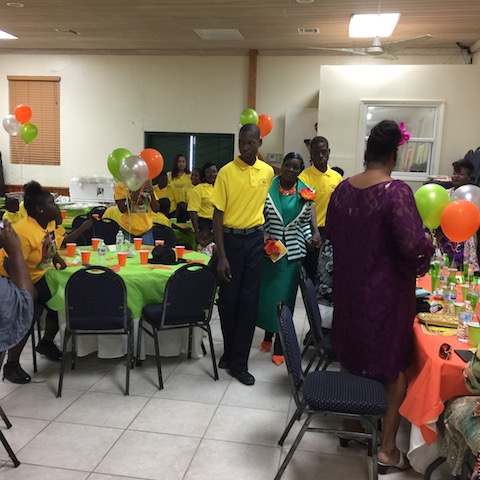 Exceptional Learners students Clifford and Kevin lead Mrs Dollymae Petty into her retirement celebration party