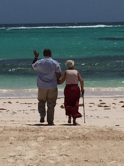 My lovely Mum being walked down the beach to have a paddle in the sea - courtesy of the very gallant Ricardo Knowles......