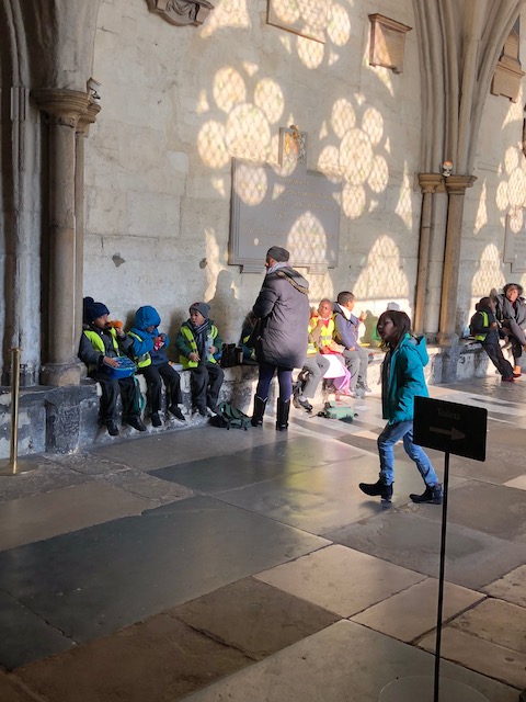 A school party at the Abbey enjoying their lunch with beautiful shadows on the wall above them......